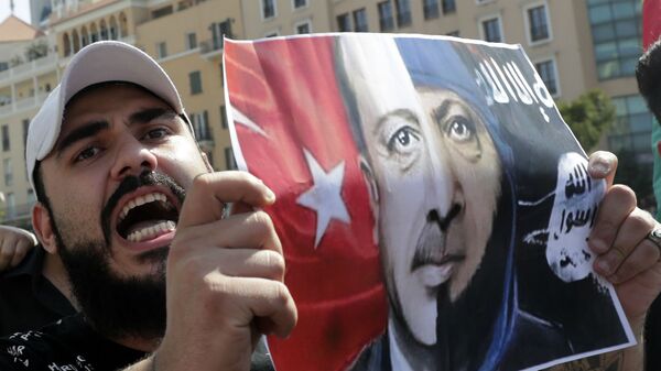 Курдский протестующий держит плакат с портретом президента Турции Реджепа Тайипа Эрдогана во время демонстрации (13 октября 2019).  Бейрут - Sputnik Армения