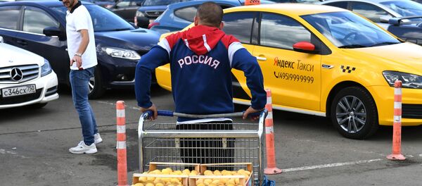 Мужчина с толстовке с надписью Россия везет тележку с абрикосами Мужчина с толстовке с надписью Россия везет тележку с абрикосами - Sputnik Армения