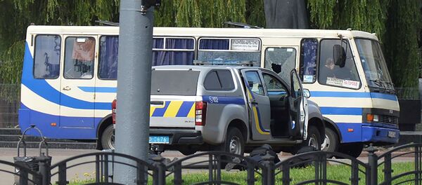 Украинские правоохранители лежат на Земле за автомобилем рядом с захваченным пассажирским автобусом (21 июля 2020). Луцк - Sputnik Армения