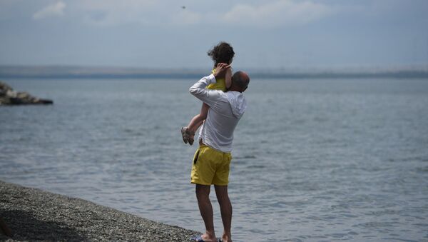 Мужчина с ребенком на берегу озера Севан (24 июля 2020). Гегаркуник - Sputnik Արմենիա