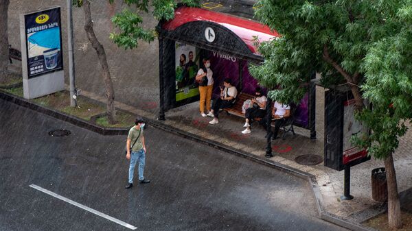Пассажиры на автобусной остановке во время дождя - Sputnik Արմենիա