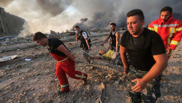 Пожарные выносят пострадавшего с места взрыва в Бейруте  - Sputnik Армения