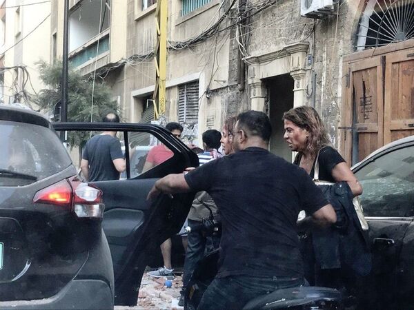 Люди, пострадавшие от осколков витрин, выбитых в результате взрыва в районе порта в Бейруте - Sputnik Армения