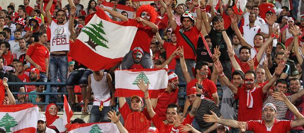 Ливанские футбольные фанаты поддерживают свою национальную команду во время отборочного матча азиатского чемпионата мира 2014 года против национальной сборной Катара (3 июня 2012). Бейрут - Sputnik Армения