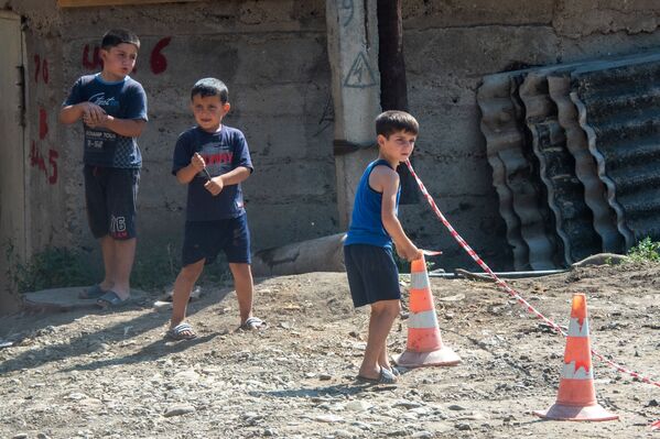 Молодые жители общины Айгепар Тавушской области помогают асфальтоукладчикам, перекрывая дорогу перед началом дорожно-строительных работ - Sputnik Армения
