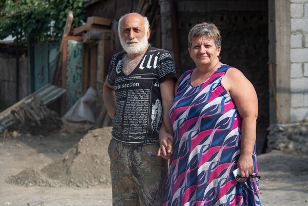 Оник и Марине Аракелян смотрят, как ремонтируют их дом. Марине называет свою улицу Улицей влюбленных в честь мужа.  - Sputnik Армения