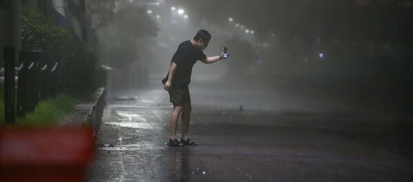 Мужчина на пляже Хэундэ в Пусане во время тайфуна Майсак в Южной Корее - Sputnik Армения