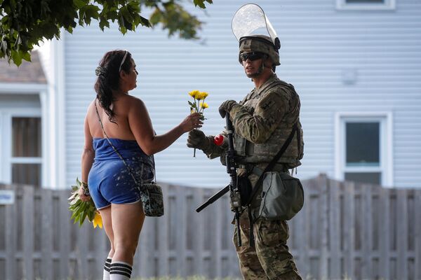 Женщина дарит цветы солдату Нацгвардии во время беспорядков в Висконсине - Sputnik Армения