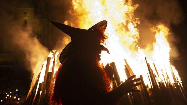Женщина в костюме ведьмы идет перед гигантским огнем во время Вальпургиевой ночи в Эрфурте (30 апреля 2018). Германия - Sputnik Армения