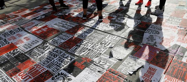 Люди стоят над плакатами BLM на площади Black Lives Matter Plaza во время марша Убери свое колено с наших шей в поддержку расовой справедливости возле Белого дома (28 августа 2020). Вашингтон - Sputnik Армения