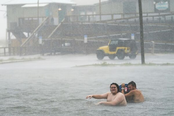 Люди купаются играют на затопленной автостоянке на пляже Наварра в Пенсакола-Бич (15 сентября 2020). Флорида - Sputnik Армения