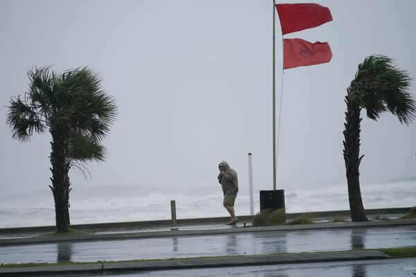 Мужчина идет по набережной залива во время урагана Салли (15 сентября 2020). Галф-Шорс, Флорида - Sputnik Армения