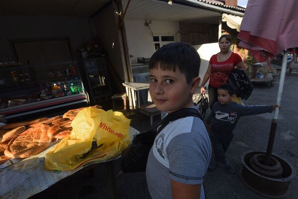 Мальчик, покупающий на рынке Степанакерта хлеб - Sputnik Армения