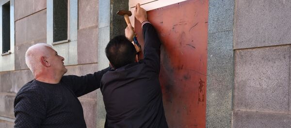 Жители Степанакерта заделывают пробитые окна и двери после обстрелов города (11 октября 2020). Карабах - Sputnik Արմենիա