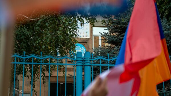 Флаг Карабаха перед зданием ООН в Армении у руках участников акции в поддержку признания независимости Карабаха (13 октября 2020). Еревaн - Sputnik Армения