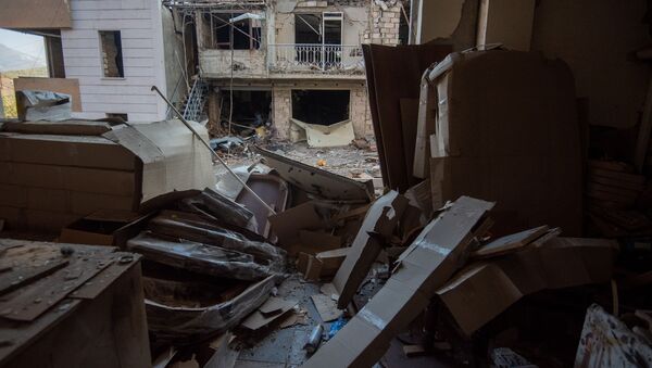 Вид на попавший под обстрел ВС Азербайджана жилой дом из окна пострадавшего мебельного магазина в Степанакерте, Карабах - Sputnik Армения