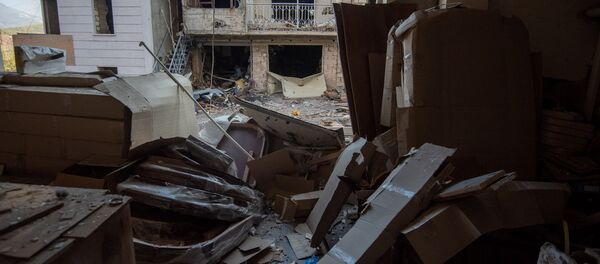 Вид на попавший под обстрел ВС Азербайджана жилой дом из окна пострадавшего мебельного магазина в Степанакерте, Карабах Вид на попавший под обстрел ВС Азербайджана жилой дом из окна пострадавшего мебельного магазина в Степанакерте, Карабах - Sputnik Армения