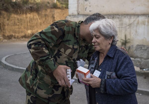Волонтер передает лекарства пожилой женщине в Степанакерте (16 октября 2020). Карабах - Sputnik Армения