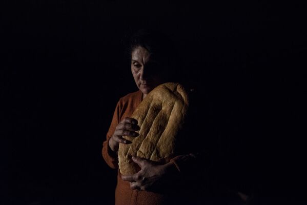 Женщина с хлебом в подвале дома из-за обстрелов Степанакерта (19 октября 2020). Карабах - Sputnik Армения