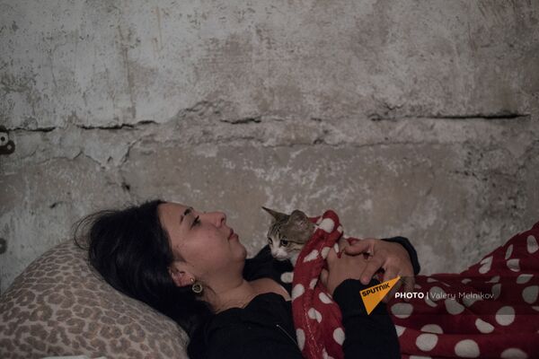 Молодая девушка с котом в подвале дома из-за обстрелов Степанакерта (19 октября 2020). Карабах - Sputnik Армения
