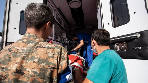 Медработники и волонтеры перевозят раненного в следствии обстрела Шуши гражданина (28 октября 2020). Карабах - Sputnik Армения