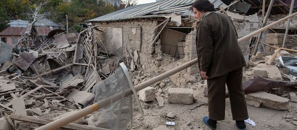Женщина осматривает разрушенный дом на месте обстрела в Степанакерте (28 октября 2020). Карабах - Sputnik Армения
