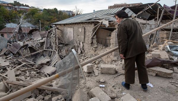 Женщина осматривает разрушенный дом на месте обстрела в Степанакерте (28 октября 2020). Карабах - Sputnik Արմենիա