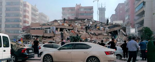 Спасатели и горожане у рухнувшего здания в Измире после сильного землетрясения в Эгейском море (30 октября 2020). Турция - Sputnik Армения