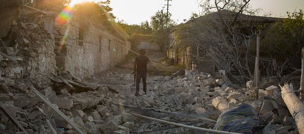 Военнослужащий у обрушенного вследствие обстрелов дома в Мартакерте (30 октября 2020). Карабах - Sputnik Արմենիա