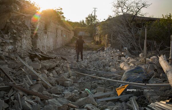 Военнослужащий у обрушенного вследствие обстрелов дома в Мартакерте (30 октября 2020). Карабах - Sputnik Армения