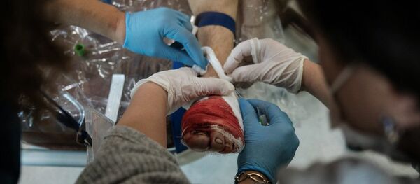 Медработники оперируют раненного мужчину во время обстрелов медицинского центра Степанакерта (28 октября 2020). Карабах - Sputnik Армения