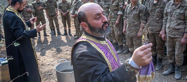 Иерей Себеос Галачян  (слева) и иерей Аристакес Оганнисян проводят обряд крещения военнослужащих недалеко от передовой линии (2 ноября 2020). Карабах - Sputnik Армения