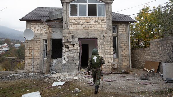 Военнослужащий входит в дом, поврежденный в результате обстрелов Степанакерта (6 ноября 2020). Карабах - Sputnik Армения