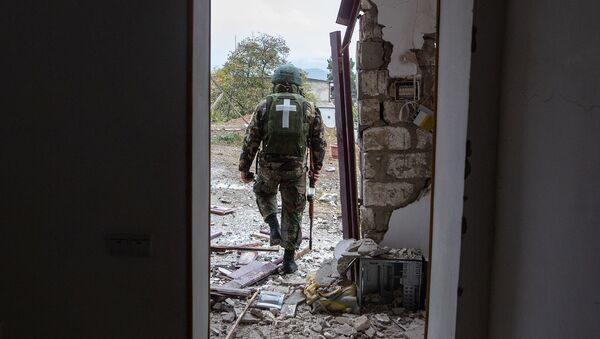 Военнослужащий возле дома, поврежденного в результате обстрела Степанакерта (6 ноября 2020). Карабах - Sputnik Армения