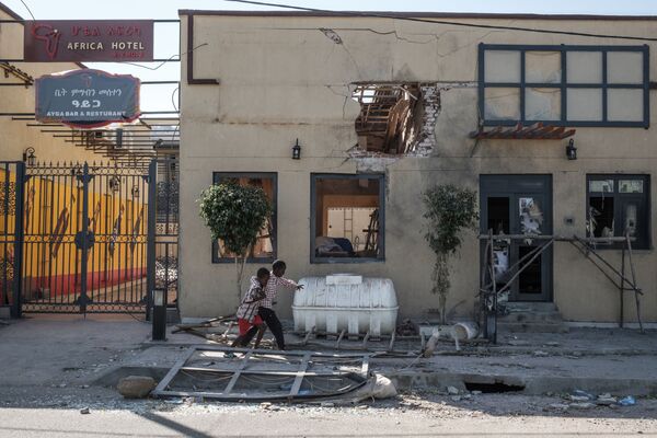 Дети играют перед гостиницей, поврежденной минометным обстрелом, в Хумере, Эфиопия - Sputnik Армения