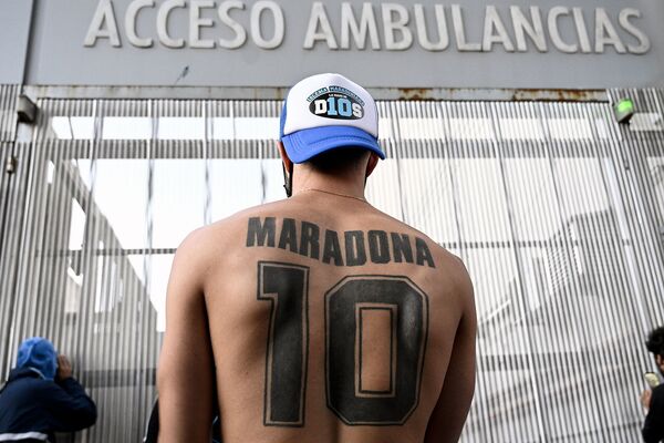 Поклонник Диего Марадоны демонстрирует свою татуировку возле больницы, где легенде футбола предстоит операция на головном мозге (3 ноября 2020). Буэнос-Айрес - Sputnik Армения