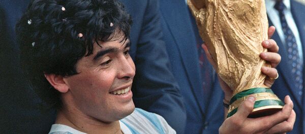 Капитан сборной Аргентины по футболу Диего Армандо Марадона показывает Кубок мира по футболу, выигранный его командой (29 июня 1986). Мехико - Sputnik Армения