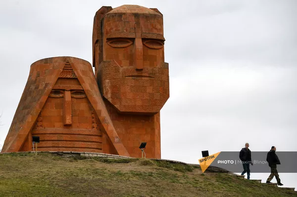 Люди возле монумента Мы - наши горы в Степанакерте