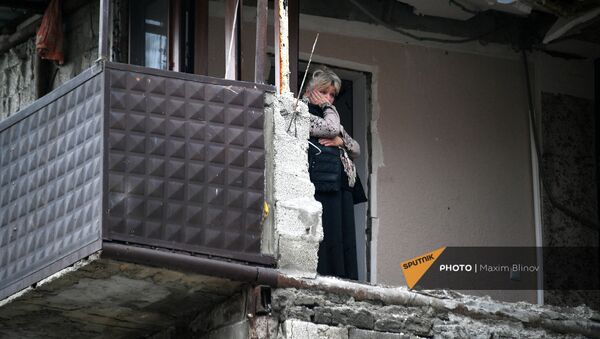 Женщина в своей квартире дома в Степанакерте, пострадавшего во время обстрела - Sputnik Արմենիա