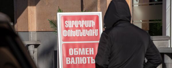 Люди проходят мимо вывески пункта обмена валюты в Ереване - Sputnik Армения