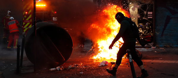 Протестующий проходит мимо огня во время демонстрации против Законопроекта о глобальной безопасности (28 ноября 2020). Париж - Sputnik Армения