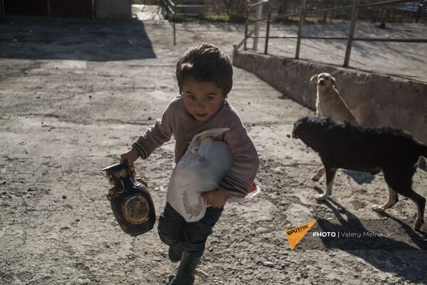 Ребенок помогает взрослым собирать вещи перед тем, как покинуть свой дом в Бердзоре (28 ноября 2020). Карабах - Sputnik Армения