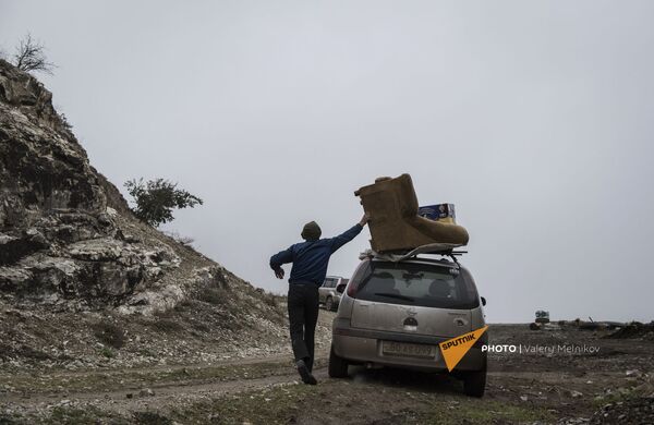 Мужчина с перегруженным вещами автомобилем покидает свой дом в городе Бердзор (30 ноября 2020). Карабах - Sputnik Армения