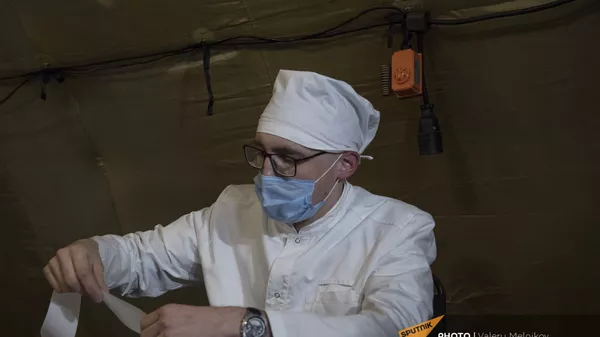 Врач проводит прием пациента на базе госпиталя развернутого Минобороны России на территории аэропорта в Степанакерте (3 декабря 2020). Карабах