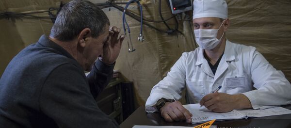 Врач проводит прием пациента на базе госпиталя развернутого Минобороны России на территории аэропорта в Степанакерте (3 декабря 2020). Карабах Врач проводит прием пациента на базе госпиталя развернутого Минобороны России на территории аэропорта в Степанакерте (3 декабря 2020). Карабах - Sputnik Արմենիա