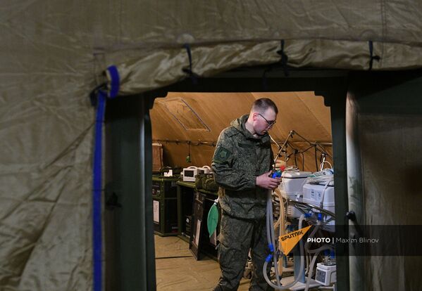 Российский военнослужащий проводит монтаж оборудования на территории мобильного полевого госпиталя неподалеку от Степанакерта (29 ноября 2020). Карабах - Sputnik Армения