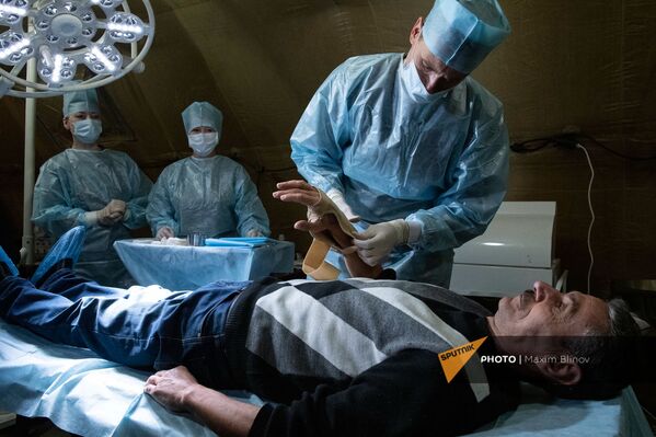 Медик оказывает помощь пациенту на базе полевого госпиталя развернутого Минобороны России на территории аэропорта в Степанакерте (1 декабря 2020). Карабах - Sputnik Армения