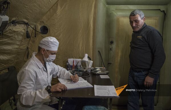 Врач проводит прием пациента на базе госпиталя развернутого Министерством обороны России на территории аэропорта в Степанакерте (3 декабря 2020). Карабах - Sputnik Армения
