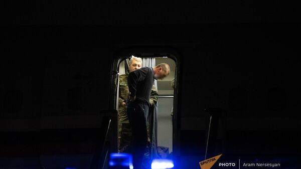 Пленные спускаются по трапу самолета в аэропорту Эребуни (14 декабря 2020). Еревaн - Sputnik Армения