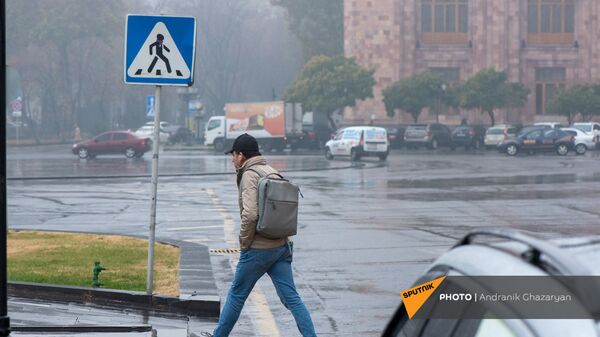 Молодой человек на площади Республики в дождливый день - Sputnik Արմենիա